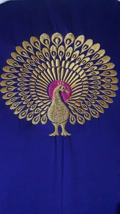 the back of a blue jacket with a gold peacock on it