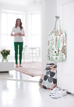 a woman standing next to a door with a purse hanging on it's side