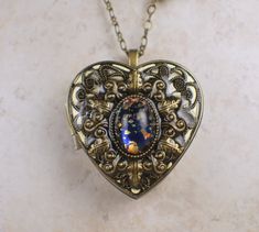 "Music box pendant. This heart shaped music box pendant is inspired by the gorgeous music box pendants of era's gone by. Music box is pill box size, please look at the dimensions for exact size. A perfect bronze heart locket has been adorned with a layer of filigree and a blue and gold glass fire opal cabochon. The cabochon is set in a bronze bezel. The filigree and bronze bezel have been finished with resin to preserve the beauty of this pendant. The music box winds from a key on the back of th Music Box Necklace, Music Box Locket, Heart Shaped Locket, Saint Helens, Jewelry Box Organizer, Clean Gold Jewelry, Magical Items, Musical Box, Box Necklace