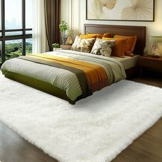 a large bed sitting in a bedroom on top of a hard wood floor next to a window