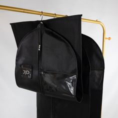 a black bag is hanging on a gold rack with it's zippers open