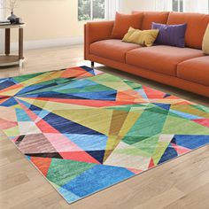 a living room with an orange couch and multicolored area rug on the floor