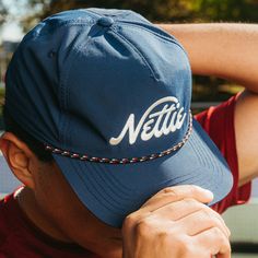 A pickleball hat that looks cool, keeps the sun out of your eyes, and can be worn on and off the court! FEATURES Performance Nylon Material Unstructured 5 Panel Mid Profile Crown Flat Pliable Bill Snapback Closure Embroidered Nettie logo Navy Adjustable Baseball Cap For Summer, Adjustable Snapback Hat With Embroidered Logo For Summer, Summer Sports Trucker Hat With Embroidered Logo, Sporty Trucker Hat With Embroidered Logo For Summer, Sporty Summer Trucker Hat With Embroidered Logo, Sporty Adjustable Trucker Hat For Golf, Adjustable Sporty Trucker Hat For Golf, Navy Sports Hat For Summer, Summer Sports Event Hat With Flat Brim