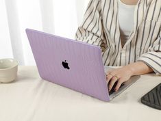 a woman sitting at a table with a laptop computer in front of her on her lap