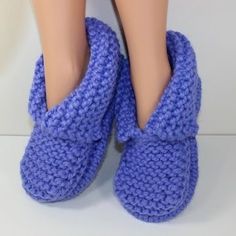 a close up of a doll's feet wearing blue slippers