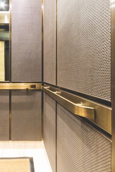 the interior of a modern bathroom with stainless steel and gold accents, including toilet paper dispensers