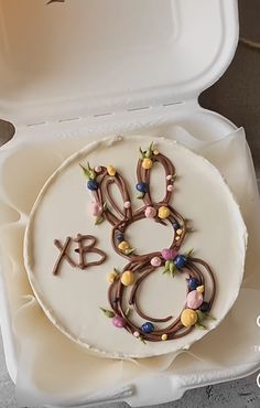 a cake in a white box with the number eight on it's icing