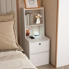 a bed with a white book shelf next to a night stand on top of it