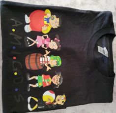 This Gildan t-shirt is a must-have for fans of El Chavo and his friends. The design features a show-off style that is sure to turn heads. The t-shirt comes in a classic black color that is versatile and can be paired with a variety of outfits. The size of the t-shirt is Large, which is a comfortable and relaxed fit for those who prefer a looser fit. The Gildan t-shirt is known for its quality and durability, ensuring that the t-shirt will last for a long time. The black color of the t-shirt is a classic and versatile color that can be worn with a variety of outfits. The t-shirt is perfect for those who want to show off their love for El Chavo and his friends. The size of the t-shirt is Large, which is a comfortable and relaxed fit for those who prefer a looser fit. The t-shirt is perfect f Black Tops With Front Print For Fan Conventions, Black Top With Front Print For Fan Conventions, Black Band Merch T-shirt For Fan Gatherings, Black Tops With Screen Print For Fan Conventions, Black Screen Print Tops For Fan Conventions, Black Tops With Character Print For Fan Gatherings, Black Fandom Screen Print T-shirt, Fun Black T-shirt With Front Print, Black Fandom T-shirt With Screen Print