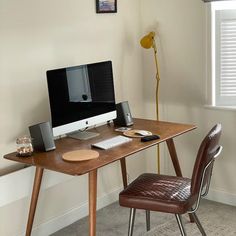 a desk with a computer on top of it and a chair in front of it