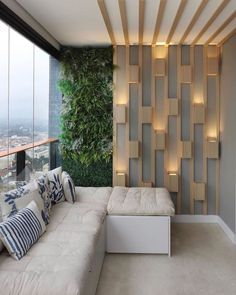 a living room filled with lots of furniture next to a tall window covered in greenery