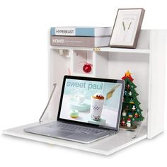 an open laptop computer sitting on top of a white shelf