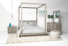 a bedroom with a canopy bed, dresser and mirror on the wall next to it