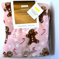 a pink blanket with gingerbreads and snowflakes on it, next to a tag