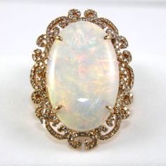 This A Fancy Fine Huge Oval Cut Fire Opal Solitaire Ring W/Diamond Filigree Halo. It Is Made Of 100% Natural 14kt Rose Gold And Is In Brand New Condition. It Has A Ctw Of 12.46ct (.88 Diamond/11.58 Opal) And Weighs 10.4 Grams. The Fancy Diamonds Have A Clarity Of Si1 And G Color. This Beautiful Custom Piece Has An Excellent Oval Cut Opal Stone, Surrounded By A Diamond Filigree Halo With Accents. Opal Solitaire Ring, Manifest Destiny, Fire Opal Ring, Fancy Diamonds, Opal Stone, Opal Ring, Diamond Halo, Opal Rings, Womens Jewelry Rings