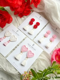 four valentine's day cards with hearts and tassels on them next to flowers