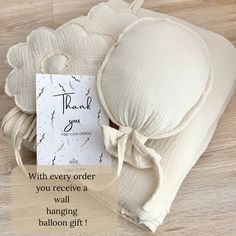 an image of a thank card and pillows on a wooden floor with the words,'thank you every order you receive a wall hanging balloon gift '