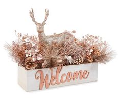 a wooden welcome sign with pine cones and glitters