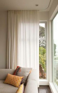 a white couch sitting next to a window in a living room