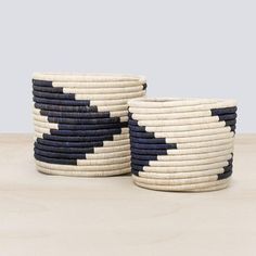 two black and white baskets sitting on top of a table