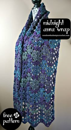 a purple and blue crocheted shawl hanging from a hook