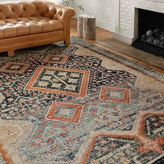 a living room filled with furniture and a rug on top of a hard wood floor