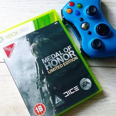 a video game controller next to a box for the xbox version of medal of honor