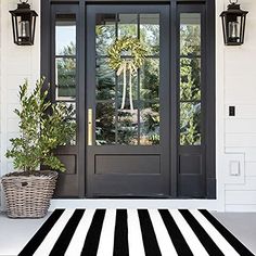 a black and white striped rug is on the front porch next to a double door