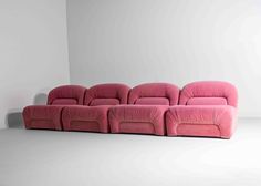 a pink couch sitting on top of a white floor