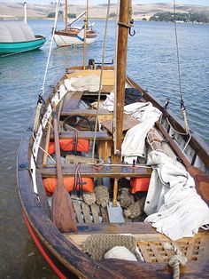 an old wooden sailboat docked in the water