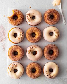 there are many donuts that have been placed on a tray with a spoon next to them