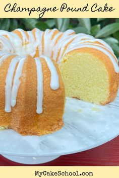 a bundt cake with white icing sitting on a plate next to a slice cut out