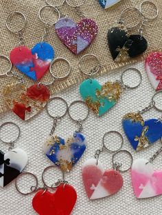 several heart shaped keychains are on a white surface with various colors and shapes