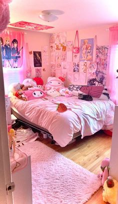 a bedroom decorated in pink and white with lots of stuffed animals on the bedding