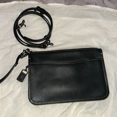 This Is A Unique Piece From Coach. Beautiful Black Glove Tanned Leather With Brown Stitching Outside Open Pocket Interior Is Lined With Beige Canvas With Brown Leather Trim 1 Open Multifunction Pocket Includes Adjustable Detachable Strap That Can Be Worn On The Shoulder Or Crossbody Includes A Wristlet Strap Perfect Handbag That Goes From Daytime To A Night Out It Is Gently Used Item And In Good Condition. Please Review Photos Carefully Before Purchase. 9”W X 6”H X 1 1/2” D Perfect Handbag, Black Gloves, Leather Wristlet, Coach Bags, Leather Trims, Tan Leather, Brown Leather, Gloves, Unique Pieces