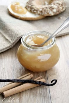 a glass jar filled with liquid sitting on top of a table next to cinnamon sticks