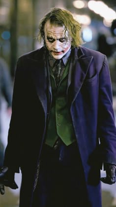 the joker is walking down the street with his hands in his pockets