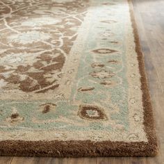 a brown and green area rug on a wooden floor