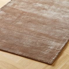 a brown area rug on top of a wooden floor next to a wood flooring