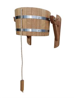 a wooden barrel hanging on the side of a wall with a metal bar attached to it