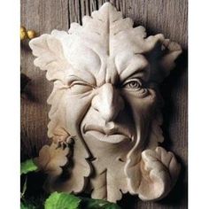 a statue of an evil looking face on a wooden wall