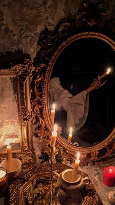 candles are lit in front of an ornate mirror