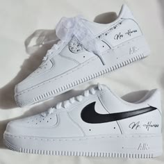 a pair of white nike air force sneakers with black and silver lettering on the soles