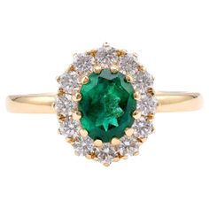 Brand: Trampet&Horn Center Stone: Emerald Cut: Oval Weight: Approximately 1.25 Carats Color: Green Accent Stone: 12 Diamonds Cut: Round Brilliant Weight: Approximately 0.58 Carats Color: F-G Clarity: VS Metal: 18K Yellow Gold Era: Vintage Inspired Circa: 2020s Hallmarks: 750 Purity Marks Size: 6.5 and can be resized Gram weight: 4.62 This exquisite ring from Trampet&Horn is a perfect blend of vintage inspiration and modern elegance. Crafted in luxurious 18K yellow gold, it features a stunning ov Luxury Yellow Gold Cluster Emerald Ring, Luxury Cluster Emerald Ring In Yellow Gold, Luxury Yellow Gold Cluster Halo Ring, Yellow Gold Cluster Emerald Ring Fine Jewelry, Cluster Emerald Ring In Yellow Gold With 17 Jewels, Formal Yellow Gold Cluster Ring With Emerald, Classic Yellow Gold Emerald Ring With Halo Setting, Vintage Cocktail Ring, Ring Cluster