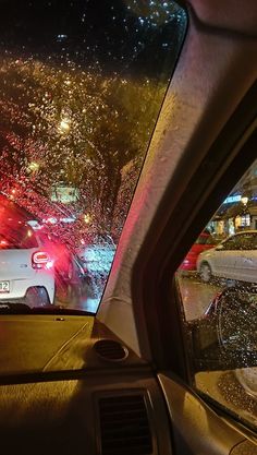 cars are parked on the side of the road in the rain at night with lights shining