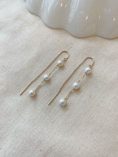 "These dainty Pearl threader earrings are classic and minimal. They look lovely paired with your special occasion outfits or a night out! The chain \"threads\" through the ear and stays in place!  Details: * Choose from 925 Sterling Silver or 14K Gold Filled * 5mm off round white Pearls * Approximately 2.25\" length * Made with all hypoallergenic materials 🤍 ✨ See all Pearl Jewelry here!: https://etsy.me/3zMbXyh WHAT TO KNOW ABOUT YOUR MAGBEE JEWELRY PURCHASE: 🤍 All MagBee pieces are safe for Dainty Chain Earrings, Minimalist Gold Sterling Silver Bridal Earrings, Minimalist Gold Bridal Earrings In Sterling Silver, Elegant White Earrings With Adjustable Chain, Elegant White Drop Threader Earrings, Delicate 14k Gold-filled White Gold Earrings, Elegant White Long Drop Threader Earrings, Elegant White Dangle Threader Earrings, Dainty White Linear Dangle Earrings