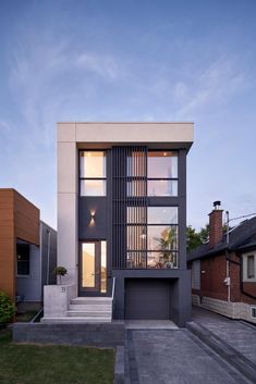 a modern house with large windows and steps leading up to the front door, in an urban area