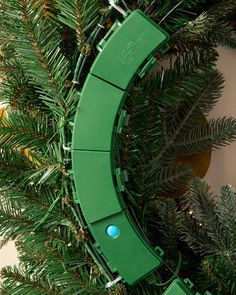 a green christmas wreath hanging from the side of a wall