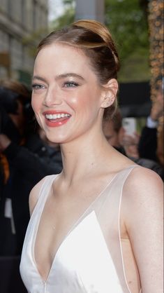 a woman in a white dress smiling at the camera