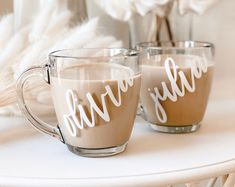 two coffee mugs sitting on top of a white table